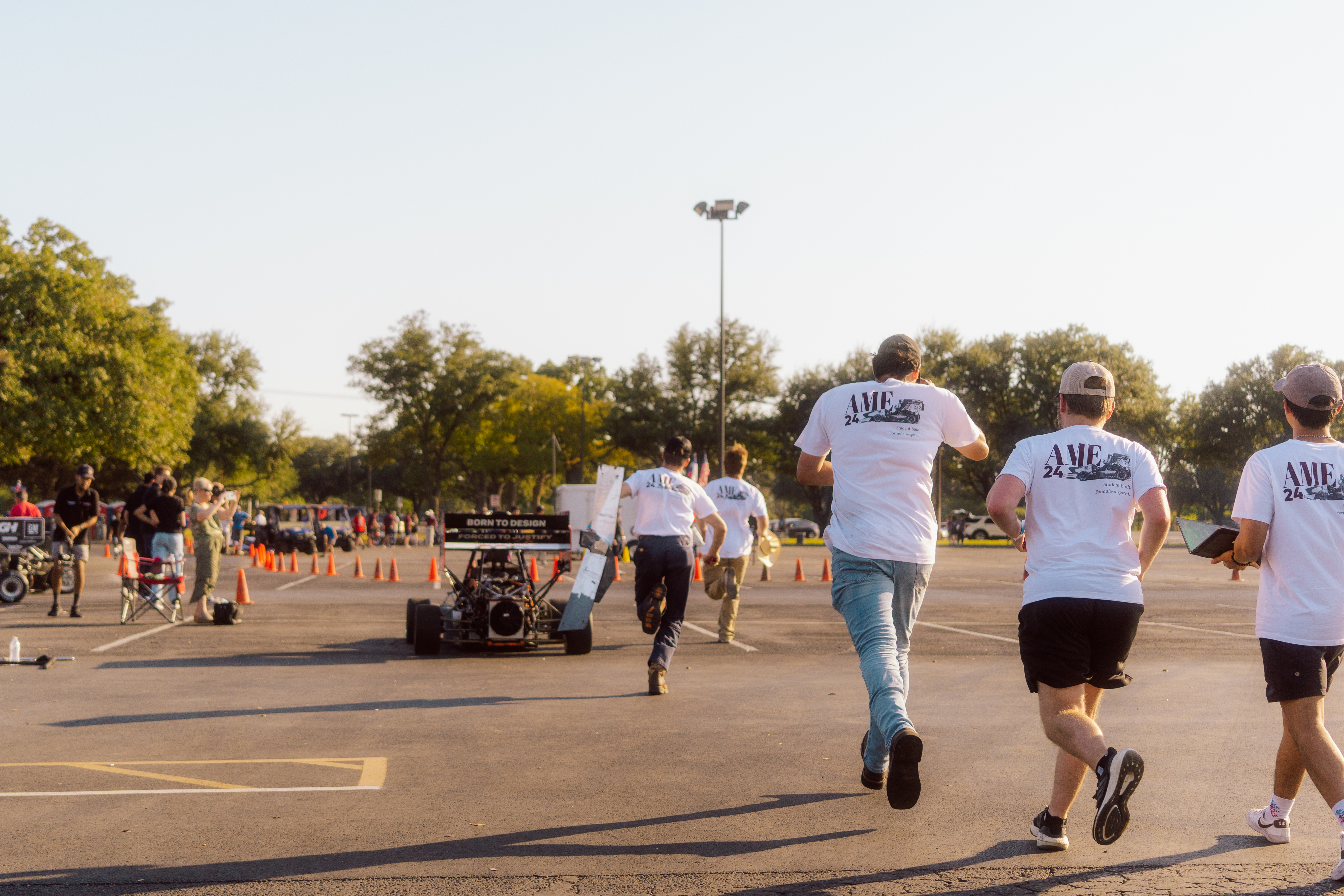 Team members running alongside the race car during a dynamic event.